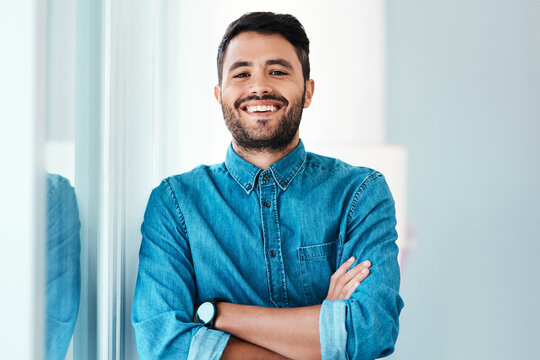 Young businessman, arms crossed and happy in portrait for new job, internship or promotion in workplace. Male person, smile and confident for junior creative director or graphic design agency