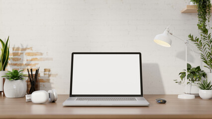 A minimalist workspace features a laptop computer mockup on a desk against the white brick wall.
