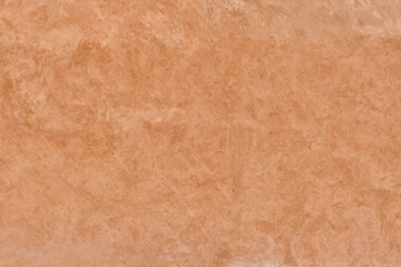 Unevenly painted terracotta-colored plastered wall