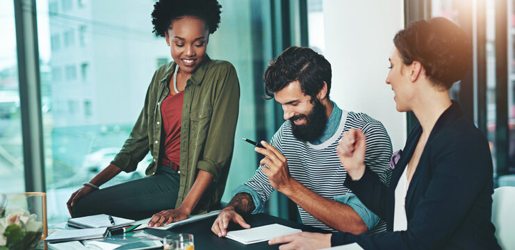 Business people, meeting and teamwork with paperwork for employee training and brainstorming in office. Designer group, communication and collaboration with documents for intern feedback and support