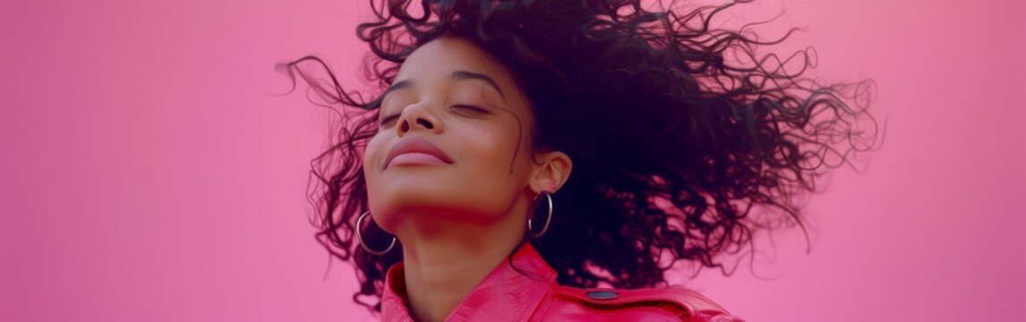 A happy woman standing with her hair flying in the wind