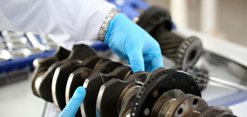 The mechanic of the service center for engine repair considers problem crankshaft on which as a...