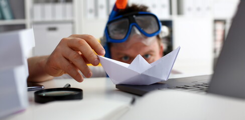Man wearing suit and tie in goggles and snorkel play with paper ship in office closeup. Count days to leave annual day off workaholic freedom fun tourism resort idea ticket sale concept