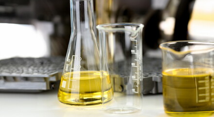 Test tube chemistry flask against background of hydroblock acp with yellow liquid purified oil from...