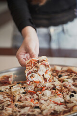 Picking up a pizza close up