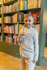 close-up in a bookstore a handsome boy stands smiling among the bookshelves a happy customer