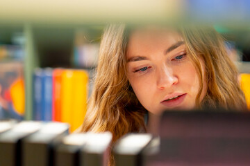 close up in a bookstore young girl chooses a new book for herself preparing for exams