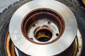 The rim is removed showing the rotor and caliper. Disc brake on car in process of new tire...