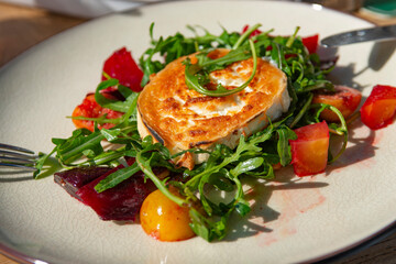 Fried goat cheese , cherry tomatoes and arugula .