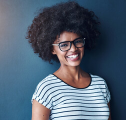 Portrait, funny and woman with glasses, happiness and confident girl on blue studio background....
