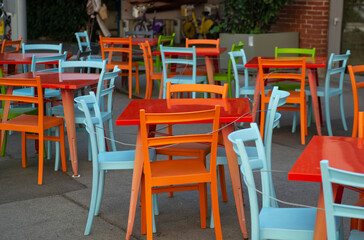 Colorful chairs and tables in a street cafe in Europe .