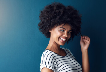 Woman, portrait and pull afro in studio with mockup space for growth, results or smile by blue...
