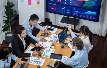 Wide top view of diverse group of business analyst team analyzing financial data report paper on...