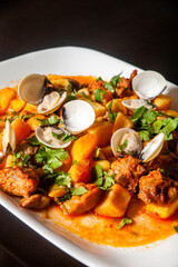 Traditional Portuguese dish: Pork Alentejana. Tender pork marinated in spices, served with clams and potatoes. Authentic taste of Portugal.
