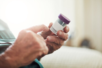 Senior man, hands and reading medication with pills for prescription, chronic illness or sickness at old age home. Closeup of elderly male person checking container for medical dose or side effects