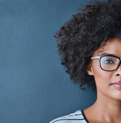 Black woman, portrait and half face with glasses as prescription with eyewear for eyesight, vision and confident. Blue background, female person and frame for spectacles, lens and service with mockup © peopleimages.com