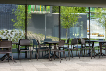Modern outdoor terrace with seating arrangement. Fashionable outdoor cafe or restaurant tables, summer time