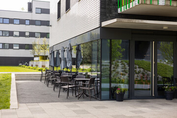Modern outdoor terrace with seating arrangement. Fashionable outdoor cafe or restaurant tables, summer time
