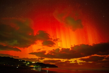 Aurora Australis dazzling over Auckland skies on 11 May, 2024. Crowd of people watching on Muriwai...