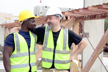 Happy harmony people at workplace, smiling white foreman and African engineer worker cuddle around...