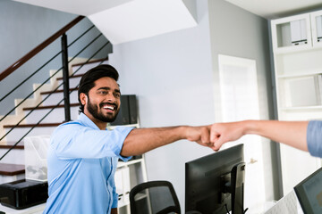 Cheerful Indian businessman partners making fist bump with a smile as a symbol of teamwork....