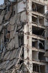 Close-up of a ruined multi-story building with exposed structural elements, depicting urban decay, destruction, and the aftermath of a demolition or natural disaster.