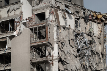 Close-up of a partially destroyed building showing exposed interior structures and scattered debris, illustrating urban decay and destruction.