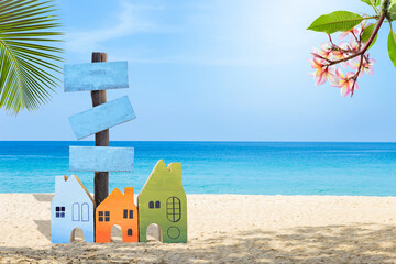 Colourful miniature house with wood sign on tropical beach, holiday and vacation house and accommodation, summer outdoor day light