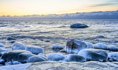 Ocean shoreline with frozen rocks and patches of water glist.