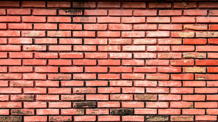 Close-up of a brick wall with signs of wear and tear, with chipping paint and faded colors