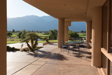 Terrace of a clubhouse overlooking a golf course in a desert landscape