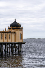 Fototapeta premium Picturesque modern building situated on the edge of a wooden pier in Varberg, Sweden