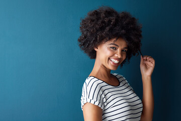 Girl, portrait and pull afro in studio with mockup space for growth, results or smile by blue...