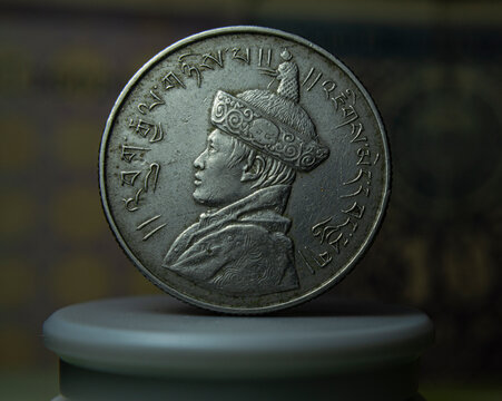 Close-up of a Bhutanese ngultrum coin against a dark background