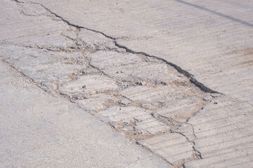 Cracks and broken texture with collapse of the old badly damaged concrete street surface