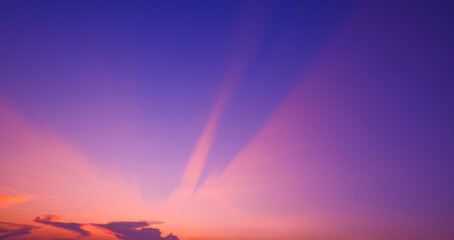 Colorful sunset sky background with pink and orange light beam on blue majestic evening sky after...