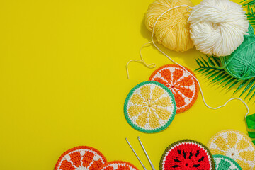 Handmade summer background. Slices of crocheted fruits, traditional accessory, bright yellow color