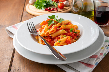 Piatto di deliziose penne all'arrabbiata, tradizionale ricetta di pasta della cucina romana, cibo...