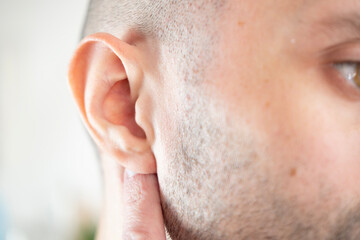 caucasian young man holding painful ear close up, hearing loss, Ear Discomfort, Hearing Test, Acute...