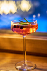 Crystal clear glass of a refreshing fruity drink with a combination of berries floating on top.