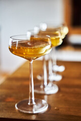 Closeup of glasses with vibrant yellow liquid standing side-by-side.