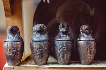 an egyptian set with three urns and four lids on display