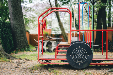 small red children's play area with a metal cart