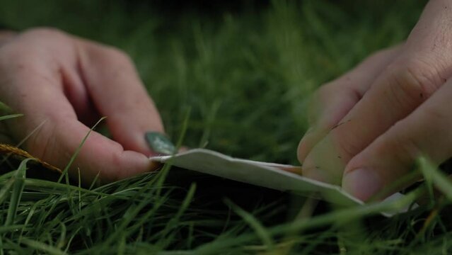 Closeup footage of adult male hands pulling a paper note out from white small envelope