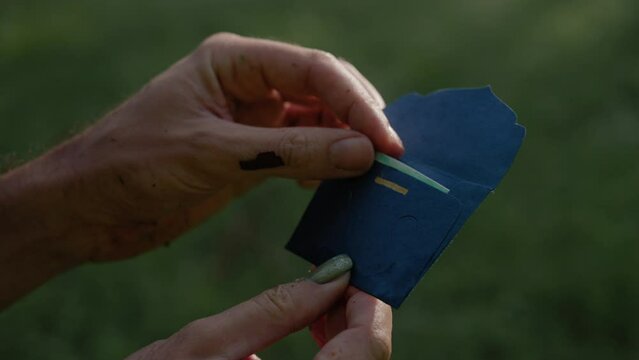 Adult male hands pulling a paper from small envelope with German text "Du Findest Meinen Mut"