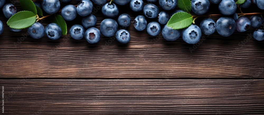 Poster a top down view of fresh blueberries is captured against a rustic wooden background providing ample 