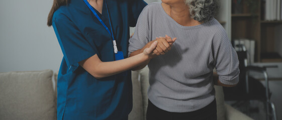 Female caregiver doing regular check-up of senior woman in her home.