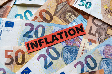 Euro banknotes background, with red ticket with text Inflation.
