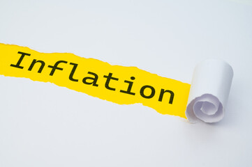 Yellow surface, with the word Inflation in black, underneath torn and rolled white cardboard.
