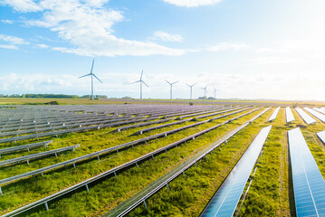 Wind turbines and solar panels farm in a field. Renewable green energy. Sunny landscape, electric...
